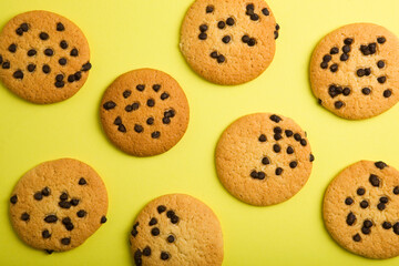 Delicious cookies with chocolate chips on a colored background