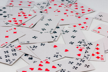 playing cards are scattered on a white background in a chaotic manner. Horizontal photo, close-up, background for creativity.