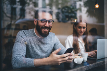 Smiling couple using gadgets in cafe