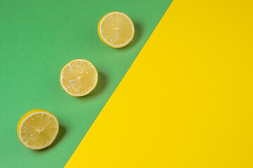 Lemons on a yellow-green background. Citrus fruit. Sliced lemon. Healthy food. Sour fruit