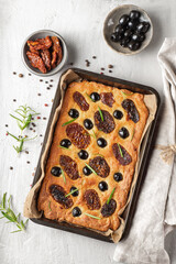 Baked focaccia with tomatoes, black olives and rosemary.
