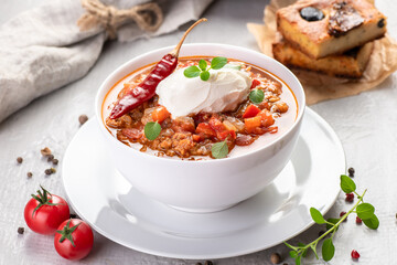 Chili con carne. Traditional recipe. Large portion of stew with beans, hot peppers, spices and fresh herbs.