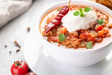Chili con carne. Traditional recipe. Large portion of stew with beans, hot peppers, spices and fresh herbs.