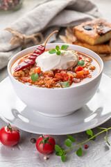Chili con carne. Traditional recipe. Large portion of stew with beans, hot peppers, spices and fresh herbs.