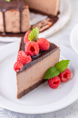 Chocolate cheesecake with fresh raspberries and mint leaves.