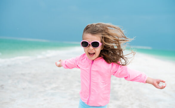 Happy Girl Running On The White Beach Of Dead Sea. Blue Sea Paradise For Summer Holidays. Fresh Wind In Your Face And Hair Fluttering In Different Directions. Travel In Israel.