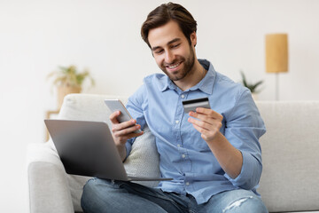 Man Using Cellphone And Credit Card Shopping Online At Home