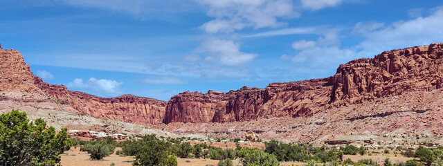 Amazing sandstone monoliths in a barren desert prairie on a blue partly cloudy summer day at Capitol Reef National Park in Torrey Utah