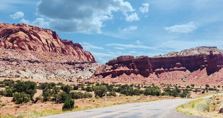 Amazing sandstone monoliths in a barren desert prairie on a blue partly cloudy summer day at Capitol Reef National Park in Torrey Utah