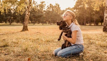 beautiful girl playing with brown puppy spaniel. Playing with the dog on the park