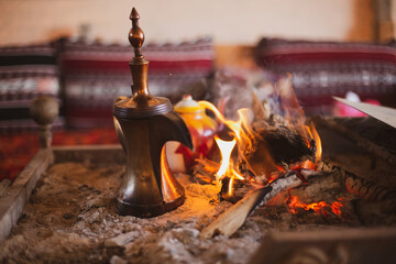 Traditional arabic coffee pot named dallah in fireplace