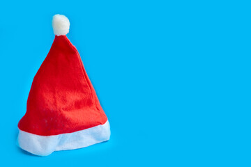 red cap of santa claus on a blue background, ban on mass celebrations in the new year and christmas, minimalistic new year's concept