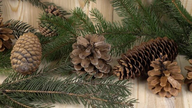 Pine branches, pine cones are laid out on pine boards, background