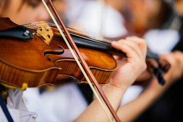 Close up violin player hands, student violinist playing violin in orchestra concert