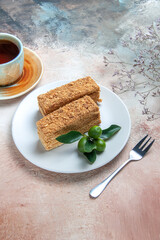 front view yummy cake slices honey cake with tea on a light background pie cake biscuit sweet