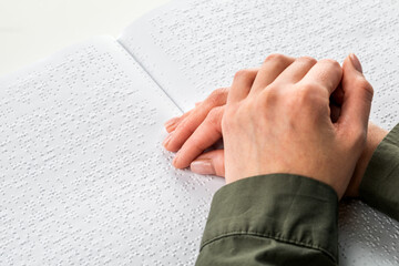 A woman reads a book written in Braille.