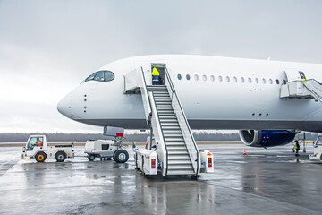 Wide body aircraft with ladder stairs to the airport parking.