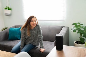 Young woman speaking a command to her smart device