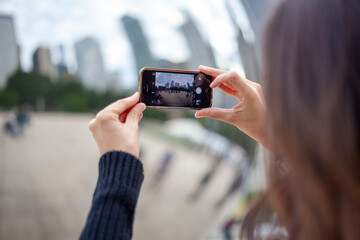 Woman takes photo of reflections in Chicago bean