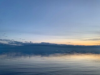 Fototapeta na wymiar blue sky and mirror water, sunset by the sea