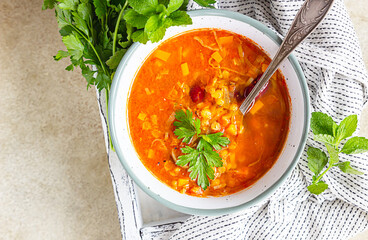 Homemade thick lentil and red bean soup with vegetables garnish with herbs. Fit and healthy, vegetarian and vegan meal. Top view.