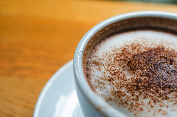 closeup coffee cup on wood table bar in restaurant or cafe with copy space. fresh beverage.