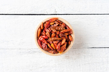Bowl of dried piripiri pepper on wooden background. Top view