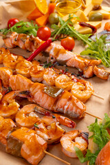 seafood skewers in sauce. Yakitori. Grilled tiger shrimps and salmon on skewers
