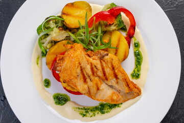 Grilled turkey fillet with vegetables on a white plate for the restaurant menu. The view from the top.