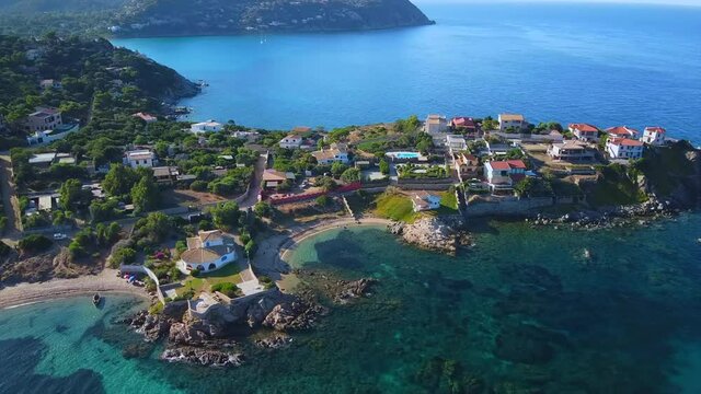 Timelapse Hyper-lapse Jib shot rising of Group of villas village residence holiday home promontory cape headland nature Sardinia coast landscape Baccu Mandara beach mediterranean sea aerial drone shot