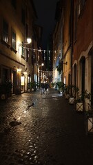 Fototapeta na wymiar Rome, ITALY - December 9 2017: Night life in Rome. People strolling on the street in centra