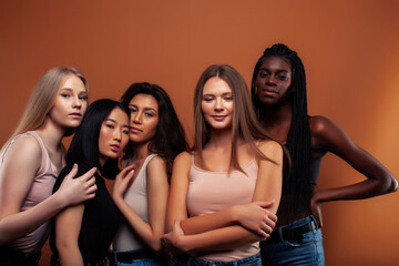 young pretty asian, caucasian, afro woman posing cheerful together on brown background, lifestyle diverse nationality people concept