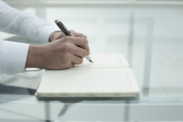 Office worker's hand writes in notebook