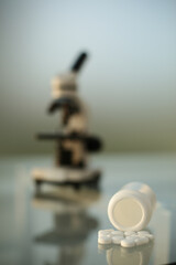 Medical microscope and pills on glass table