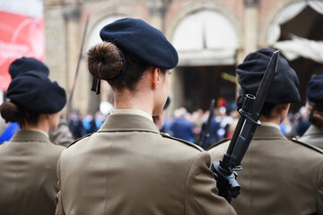 Back view of military woman with a bayonet rifle - Detail with uniformed women standing for the...