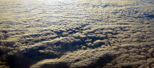 Aerial view of clouds and sky. Bird eye view from airplane window. Clouds panorama from airplane