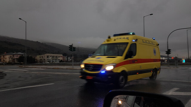 abulance moving fast in the nigth lights on  rainy weather asphalt