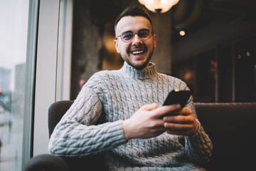 Optimistic man chatting on smartphone