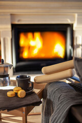 Crutches near the chair with a plaid and table with breakfast on the background of the fireplace. World disability day