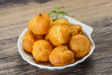 Sweet tasty profiteroles heap in the bowl