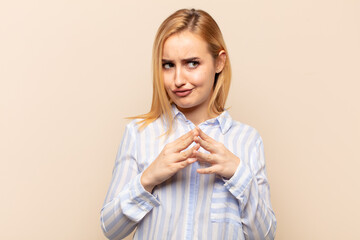young blonde woman scheming and conspiring, thinking devious tricks and cheats, cunning and...