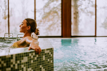 Young woman relaxing in the whirlpool bathtub at the poolside