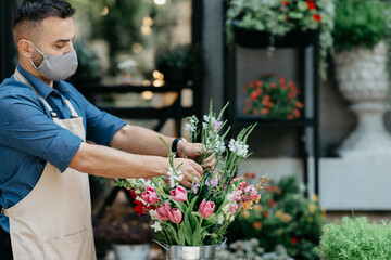 Small business, male florist focused on composition in flower shop
