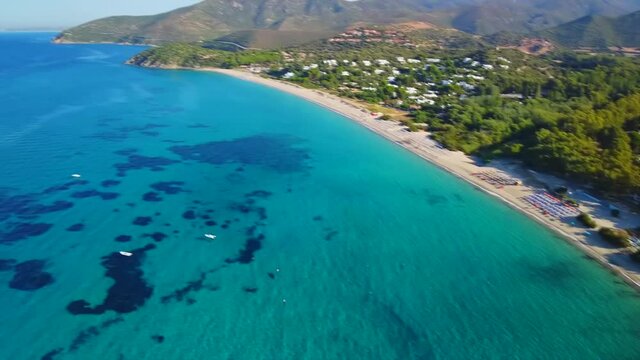 Pan orbit shot of promontory cape headland foreland nature Sardinia coast Sardinian landscape Baccu Mandara beach mediterranean sea aerial drone shot beach umbrellas amazing sea beach resort