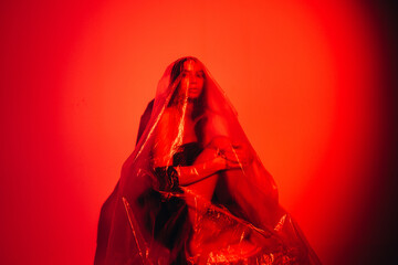 Red art portrait. Pandemic self isolation. Quarantine loneliness. Anxious defocused woman covered...
