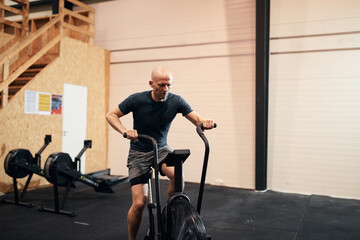 Fototapeta na wymiar Man working out on a stationary bike in a gym