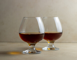 Cognac in a glass on a beige background. Alcoholic beverages. Bar.