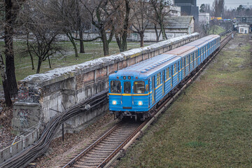 Fototapeta premium Blue subway train Ezh runs along the railway in cloudy day. Yezh-3 train - Kyiv, Ukraine