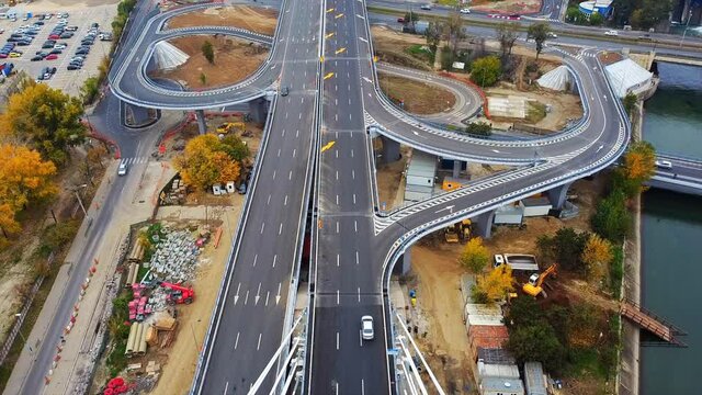 Ciurel passage, bridge over a river with moving cars, construction works near it. View from the drone. Bucharest, Romania