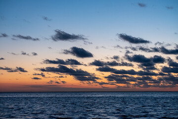 Obraz premium View of the setting sun shining on the Sea and reflected on the beach, clouds with sun-shining edges. Landscape. High quality photo showing concept of freedom and dreams